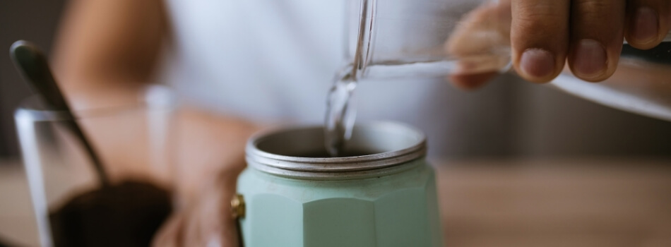 Mujer añade agua a su cafetera italiana